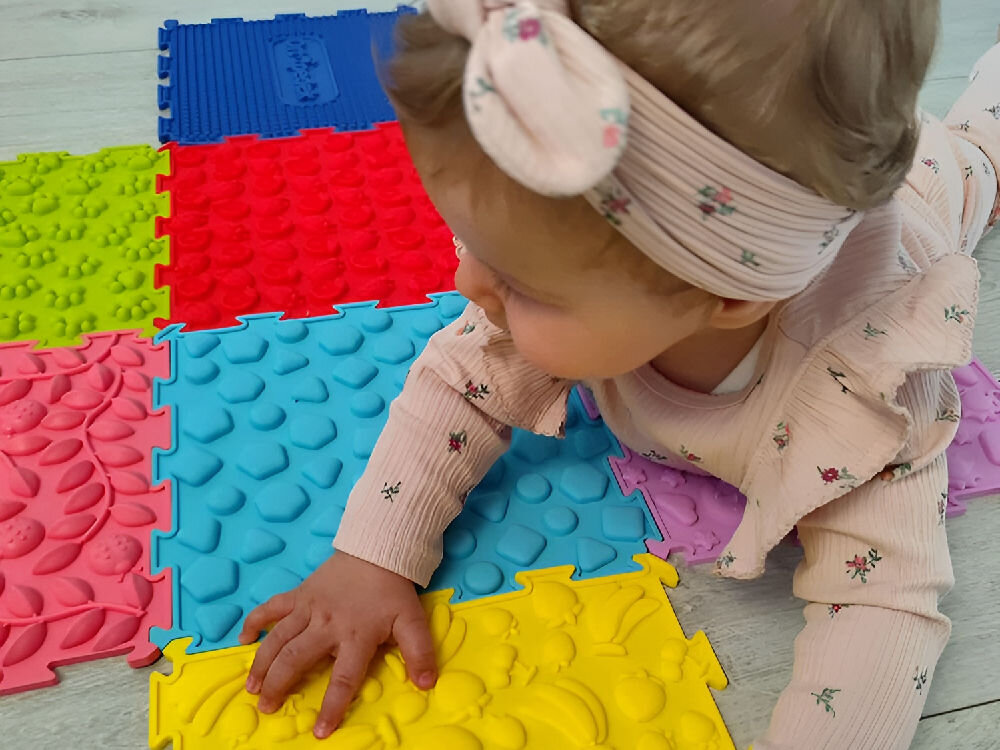 Mata sensoryczna ORTOPEDEK 128931 24.5 x 24.5 cm (8 elementów) WielokolorowyMata sensoryczna ORTOPEDEK 128931 24.5 x 24.5 cm (8 elementów) Wielokolorowy Widok z góry na kompletną ścieżkę sensoryczną Ortopedek ułożoną w kształt ośmiobocznego pierścienia. Zestaw zawiera puzzle o zróżnicowanych fakturach: kaktusy, ślady łap, wypustki, kamienie oraz słońca i księżyce.