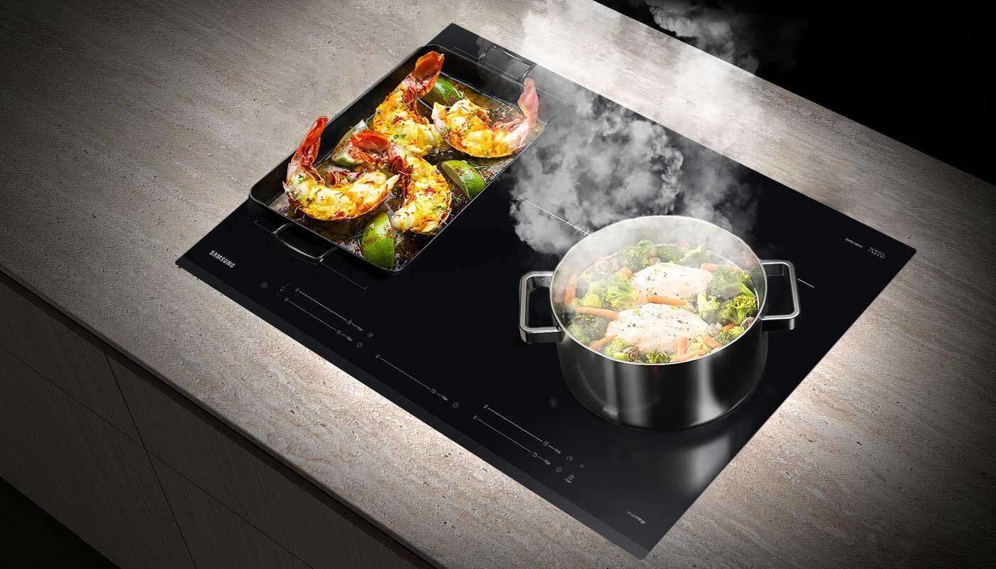 Płyta indukcyjna Samsung NZ85C5047GK oraz garnki i patelnie o różnej wielkości