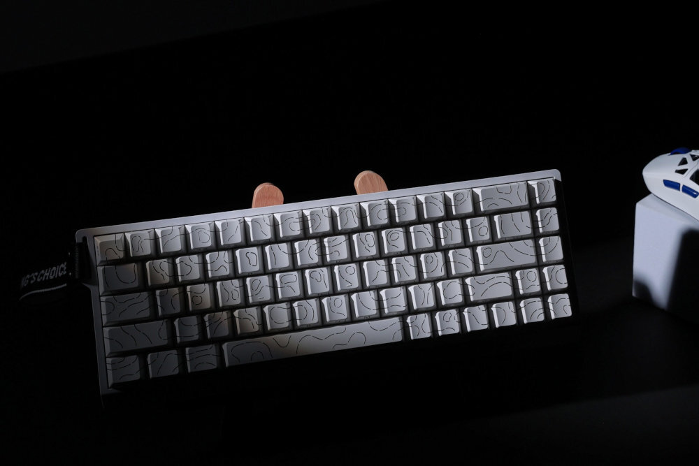 MCHOSE MC-ACE68 konstrukcją aluminiowej płycie silikonowych wkładkach tłumiących wbudowaną pamięć na profile oprogramowanie MCHOSE edycję makr, przypisywanie funkcji i zmianę trybów działania (m.in. Snap Tap, SOCD, DKS) - biała klawiatura w cieni, obok widać kawałek myszki