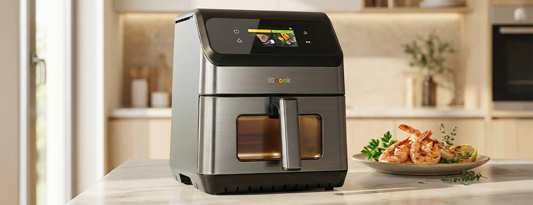 Frytkownica beztłuszczowa iCoook MFR-IC-01 z podświetlonym wnętrzem na blacie kuchennym. Obok krewetki na talerzu.