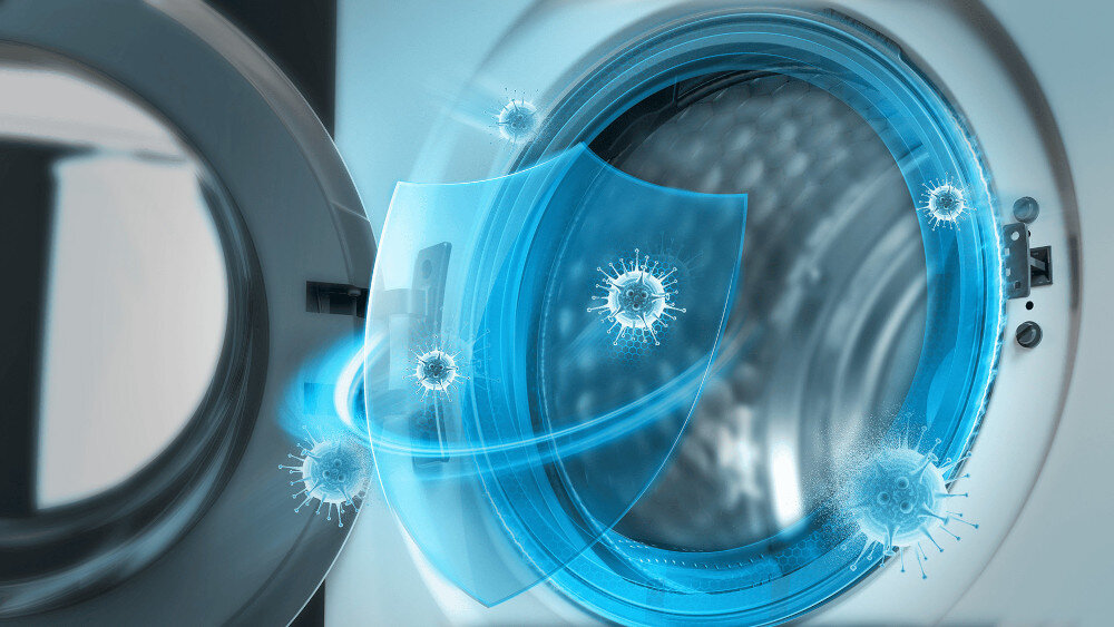 PRALKA TCL FP0944WA0PL Ilustracja przedstawia otwarte drzwi pralki, przed którymi pojawia się półprzezroczysta, niebieska tarcza ochronna zatrzymująca unoszące się wokół wirusy, symbolizując antybakteryjną ochronę wnętrza urządzenia i prania technologia antybakteryjna ochrona przed bakteriami czysty bęben higiena świeżość pralka długotrwała czystość