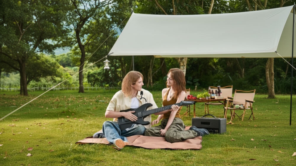 Gitara AeroBand Technologia MIDI i wbudowane brzmienia, Cyfrowa konstrukcja, , osoby siedzące na kocyku w plenerze, osoba z gitarą w rękach