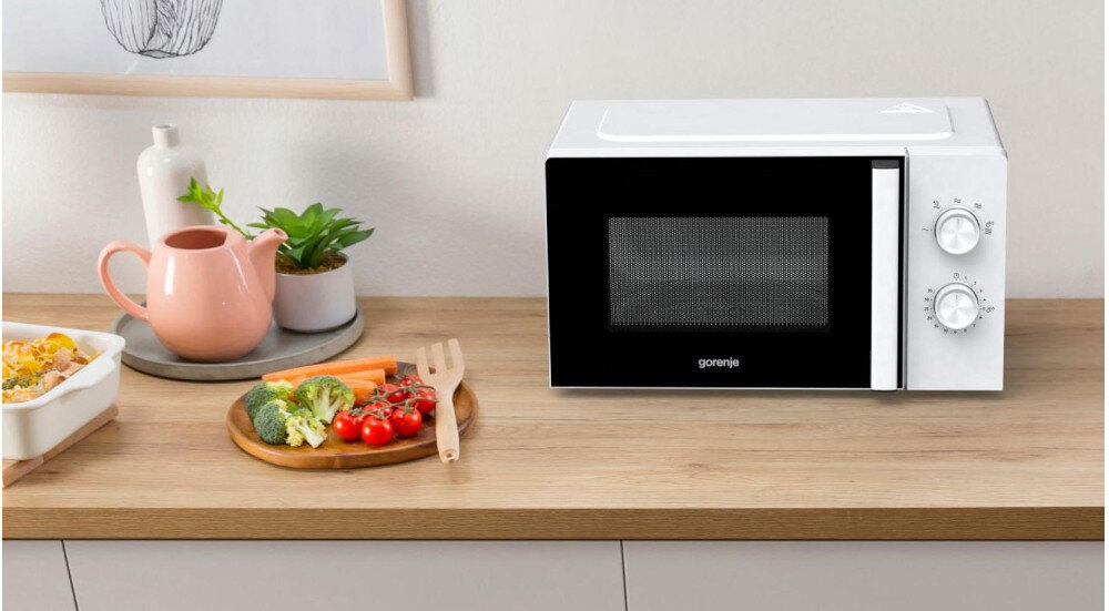 KUCHNIA MIKROFALOWA GORENJE MO17E1W lifestyle kuchnia blat akcesoria kuchenne warzywa na talerzu kuchenka front czarna zamknięta
