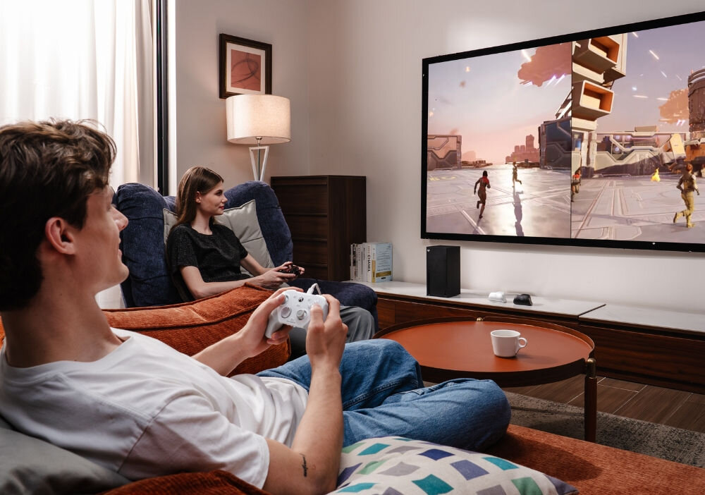 Kontroler GAMESIR G7 Pro Tri-Mode Biały
                mężczyzna i kobieta naprzeciwko telewizora z kontrolerami w rękach cztery dodatkowe przyciski własny układ sterowania mechaniczne mikroprzełączniki optyczne dokładne kliknięcia żyroskop