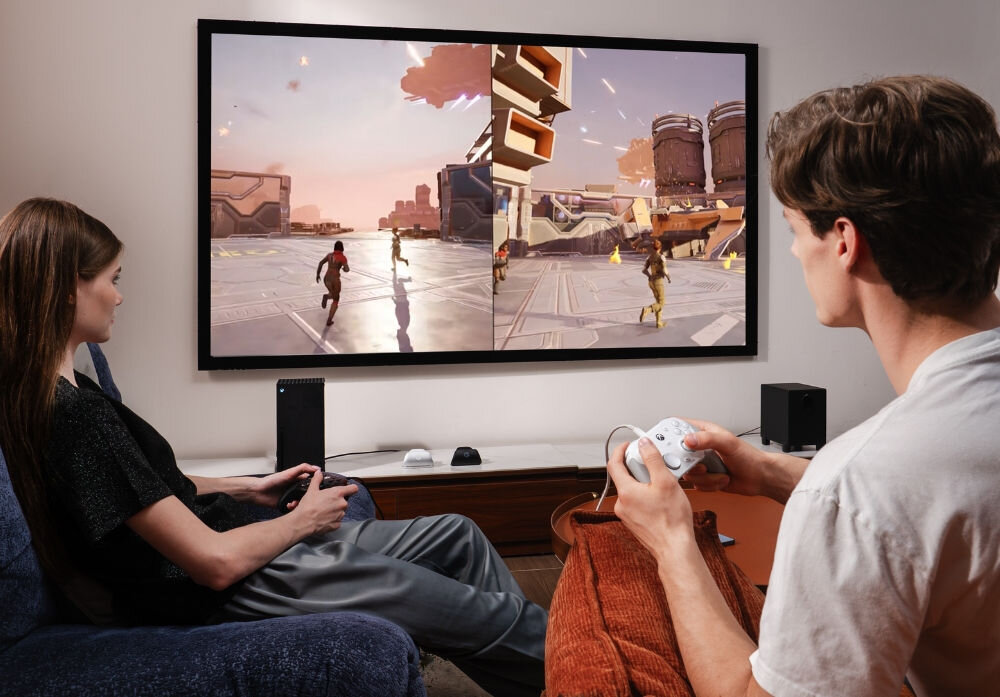 Kontroler GAMESIR G7 Pro Tri-Mode Biały
                mężczyzna i kobieta naprzeciwko telewizora z kontrolerami w rękach magnetyczny trzyczęściowy front stacja ładująca start-stop bateria pojemność 1200 mah cztery silniki wibracyjne zróżnicowany feedback