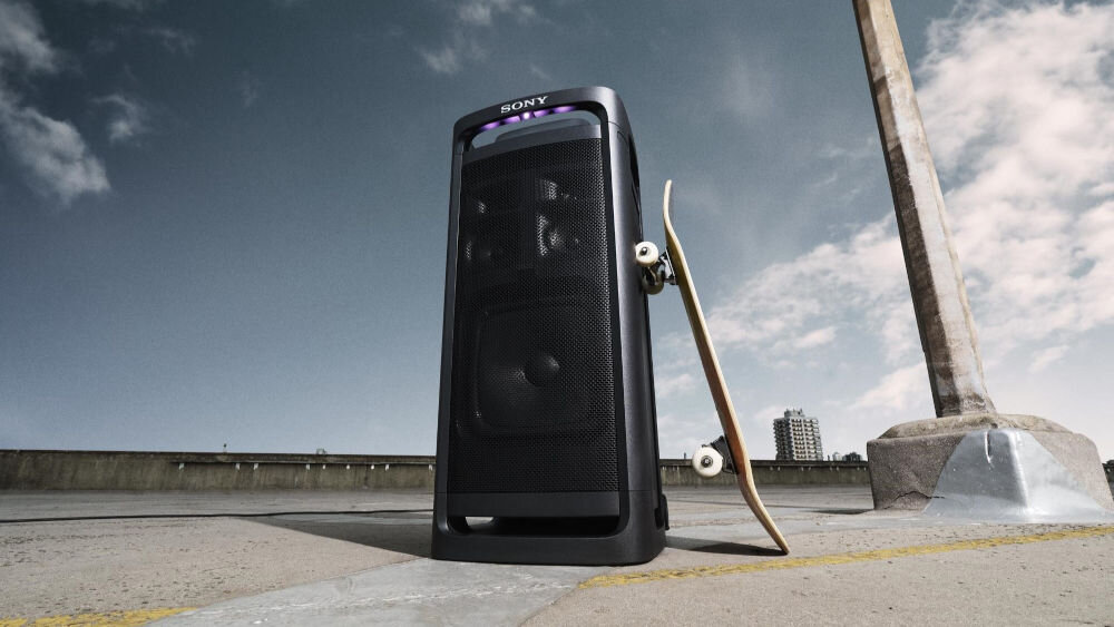 Power Audio SONY ULT Tower 9 AC Karaoke Czarny z opartą o niego deskorolką na betonowym podłożu głośnik x-balanced cztery głośniki wysokotonowe imprezowy dźwięk aplikacja sony korektor equalizer