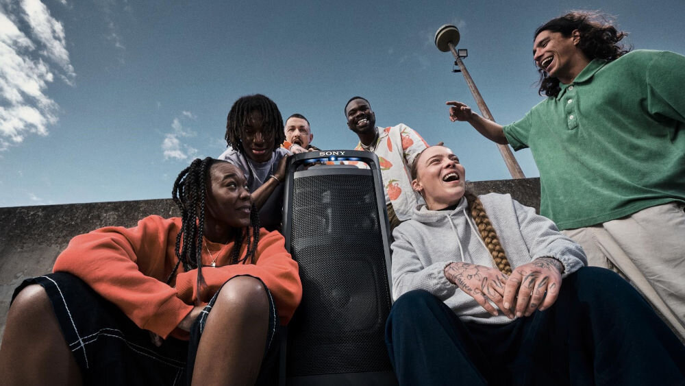 Power Audio SONY ULT Tower 9 AC Karaoke Czarny rozbawione osoby siedziące obok głośnika aplikacja sony sound connect ult power sound tryb stereo pair funkcja party connect parowanie głośników parowanie do 100 głośników