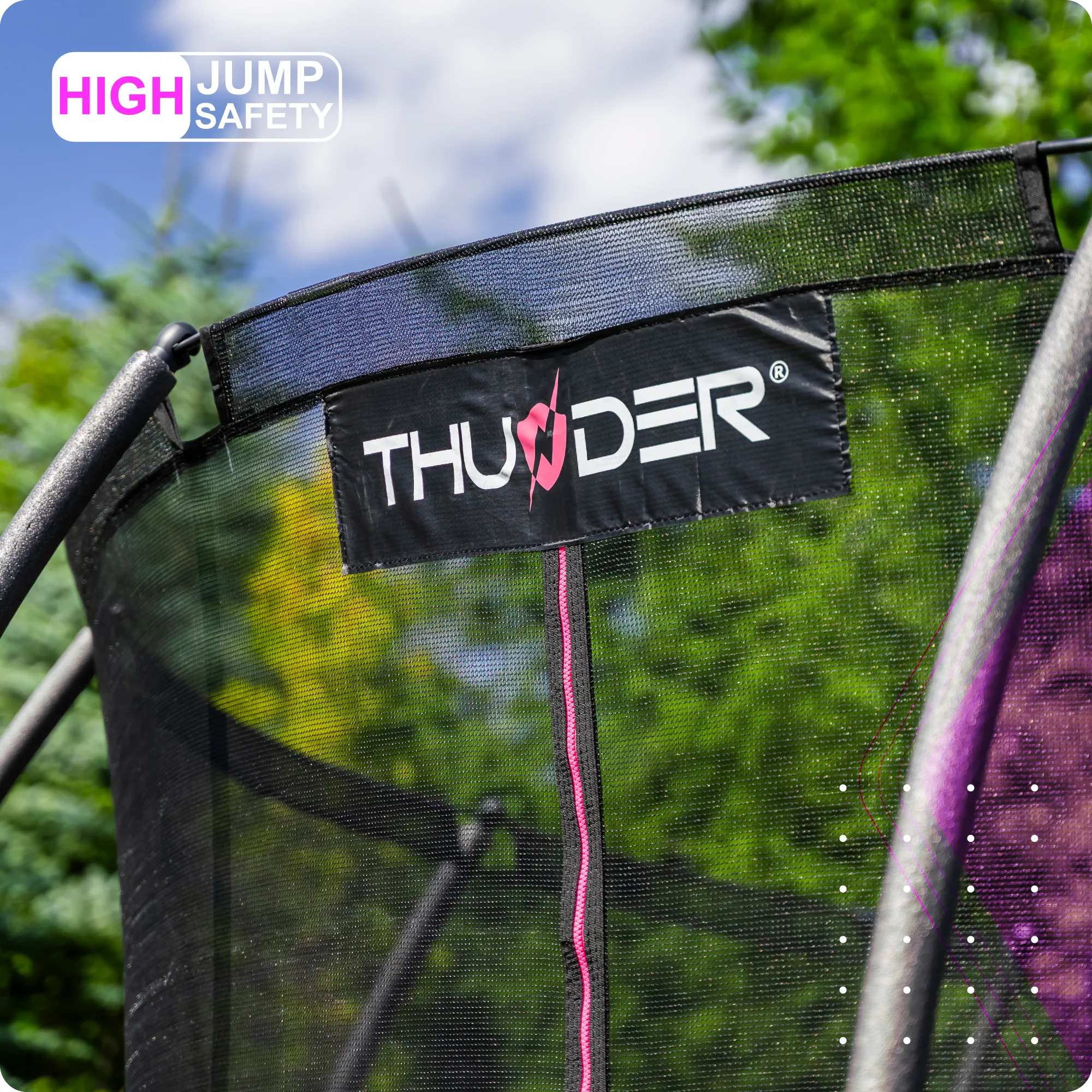 Na zdjęciu widoczna jest siatka trampoliny z logo \'THUNDER\' oraz napisem \'HIGH JUMP SAFETY\' w rogu. W tle znajdują się drzewa i niebo z chmurami.