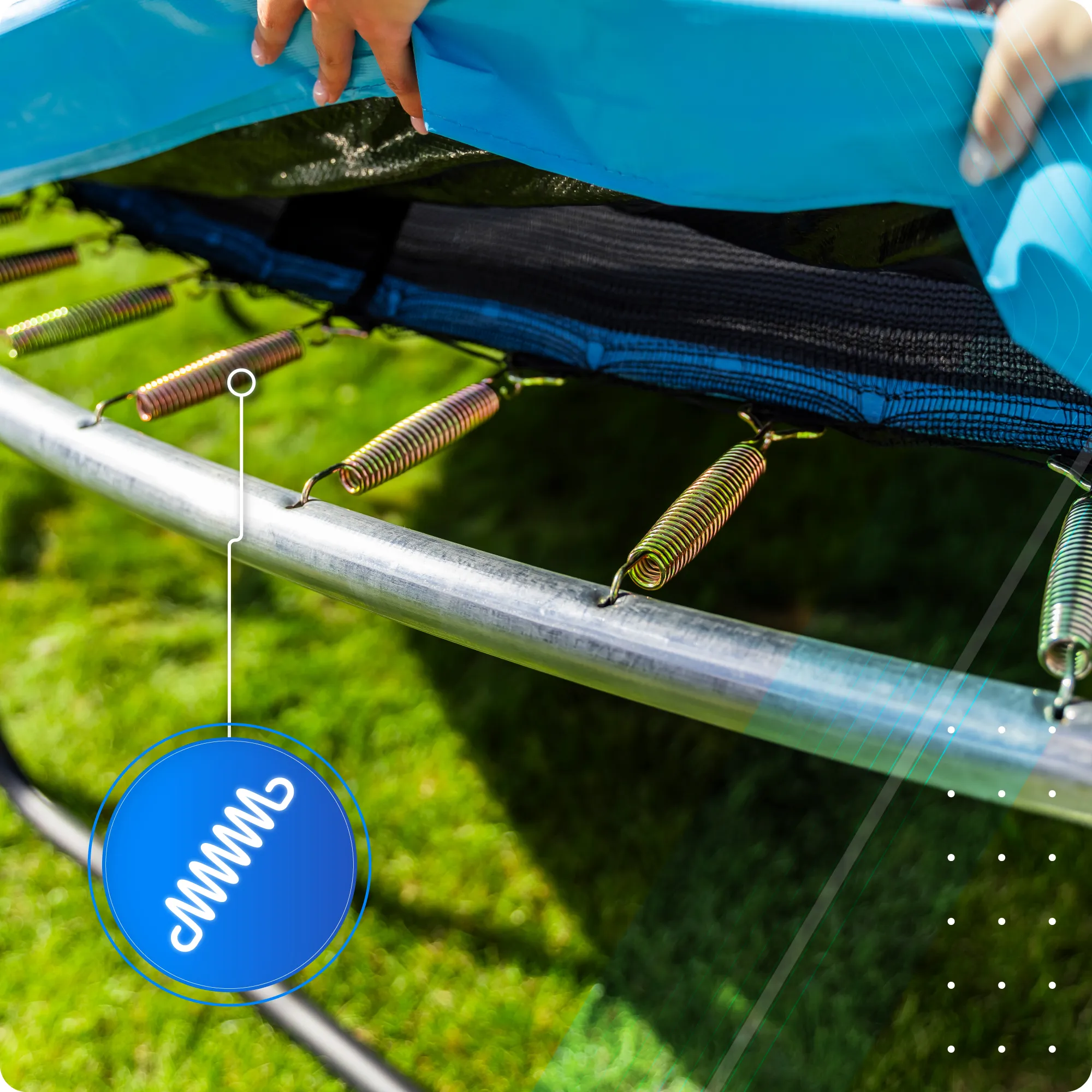 Zbliżenie na metalowe sprężyny trampoliny przymocowane do stalowej ramy, z niebieską osłoną ochronną. W tle widoczna jest zielona trawa, a na obrazie znajduje się niebieska ikona z białym symbolem sprężyny.