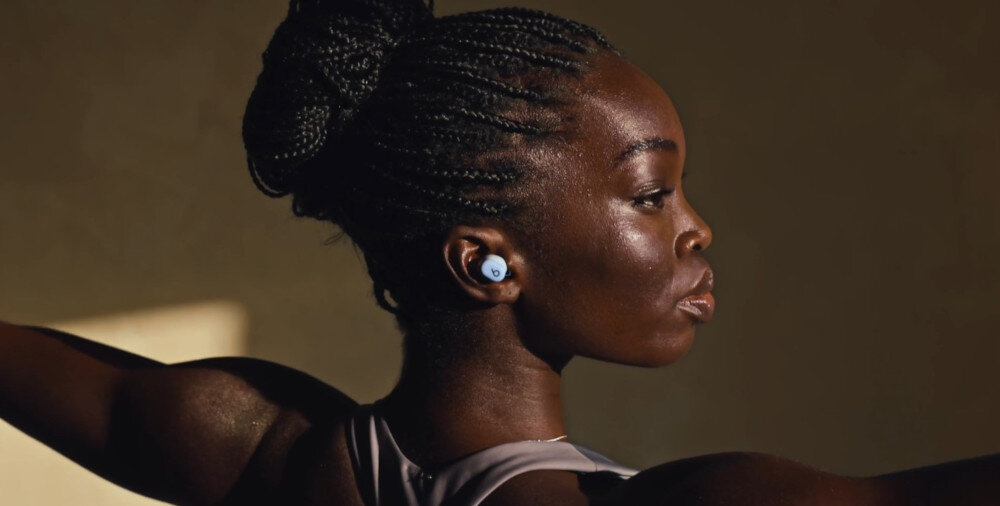 Słuchawki dokanałowe BEATS Solo Buds zrównoważone brzmienie muzyki, odwzorowanie basów, bogactwo detali, osoba z założonymi słuchawkami dokanałowymi uprawiająca jogę