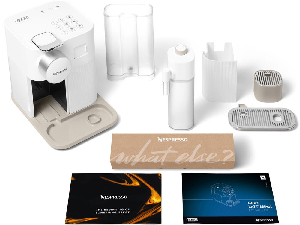 Na obrazie znajduje się biały ekspres do kawy z kilkoma akcesoriami, w tym pojemnikiem na mleko i tacką ociekową. Widoczne są również broszury z napisami \'NESPRESSO THE BEGINNING OF SOMETHING GREAT\' oraz \'GRAN LATTISSIMA MY MACHINE\', a także pudełko z napisem \'NESPRESSO what else?\'.