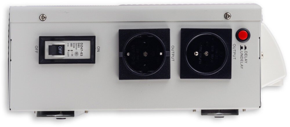 Stabilizator napięcia VOLT AVR Zbliżenie na boczny panel sterowania zawierający od lewej włącznik nadprądowy, gniazdo bezpiecznika, gniazdo sieciowe typu Schuko oraz czerwony przycisk zmiany trybu opóźnienia