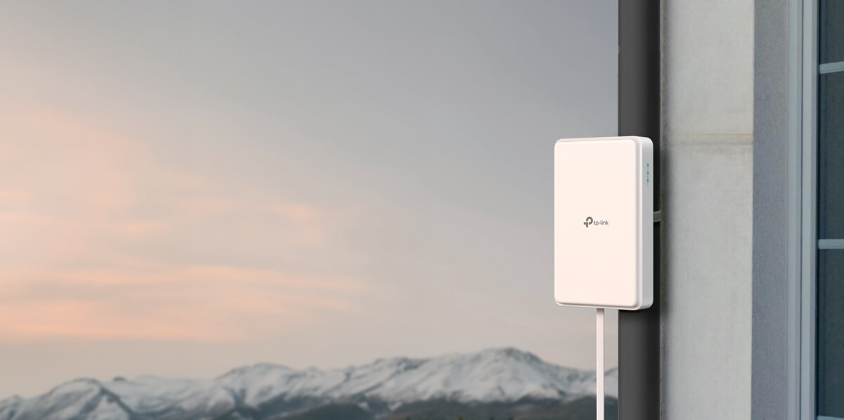 Router TP-LINK NE200-Outdoor 5G Gniazdo SIM, IP66, temperatura, ochrona, pogoda, router zamontowany do ścianki domu, w tle górzysty teren