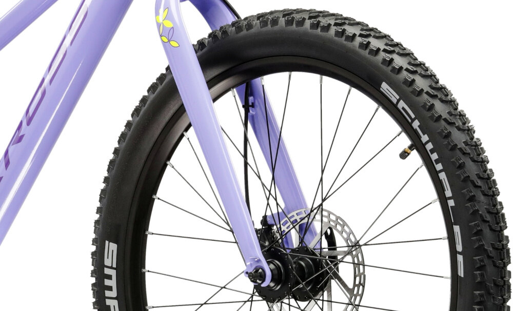Zbliżenie na przednie koło fioletowego roweru z widocznym amortyzatorem i oponą marki Schwalbe.