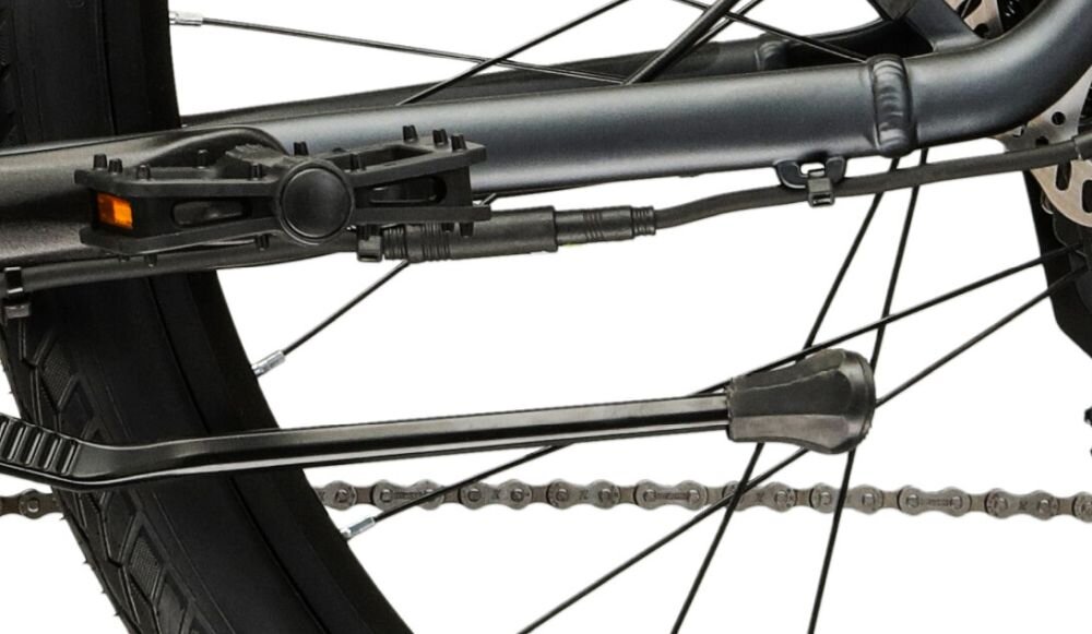 Zbliżenie na tylne koło roweru z widocznym mechanizmem hamulcowym tarczowym i częścią ramy w kolorze bordowym. Na szprychach znajduje się żółty odblask.