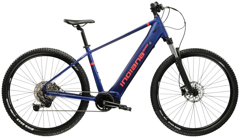 Rower elektryczny w kolorze zielono-czarnym z napisem \'INDIANA\' na ramie. Posiada grube opony z napisem \'KENDA\' oraz widoczny mechanizm napędowy i przerzutki.