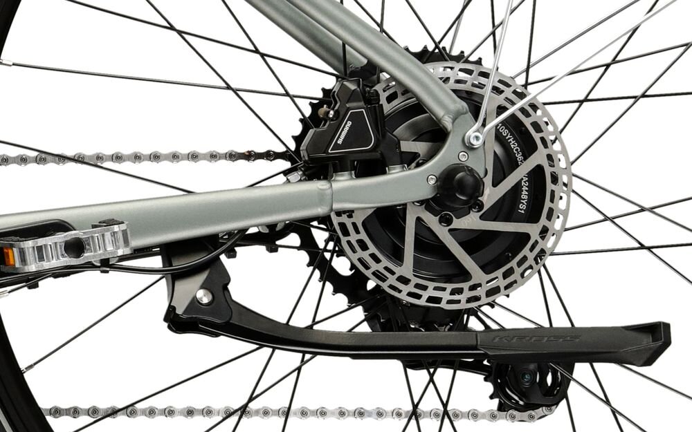 Zbliżenie na tylne koło roweru z widocznym mechanizmem hamulcowym tarczowym i napisem  na zacisku. Rama roweru jest w kolorze grafitowym.