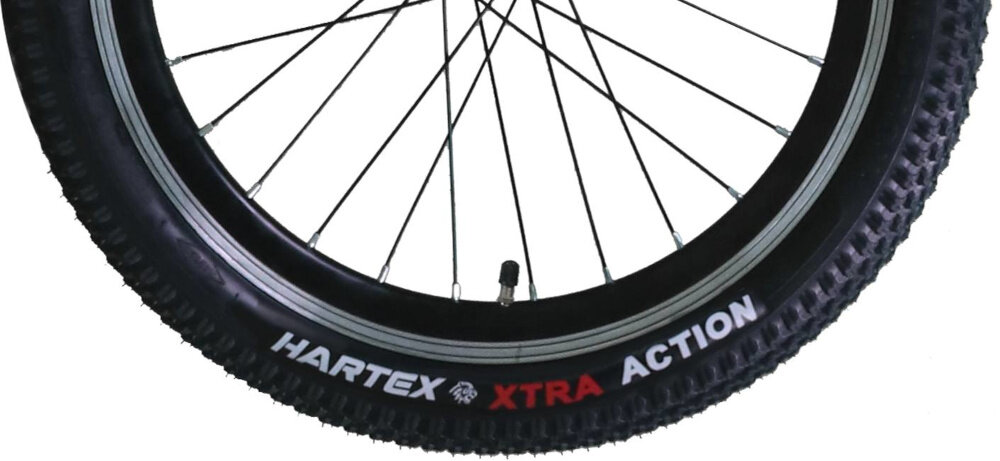 Obraz przedstawia oponę rowerową z widocznym napisem \'HARTEX XTRA ACTION\'. Opona ma wyraźny bieżnik i jest zamontowana na metalowej obręczy z szprychami.