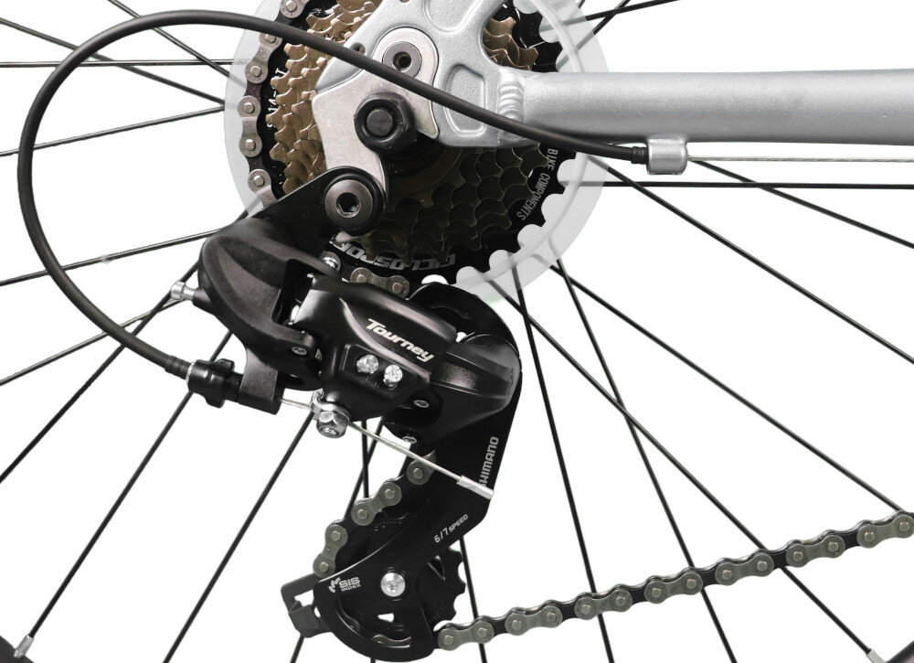 Zdjęcie przedstawia mechanizm przerzutki rowerowej z widocznym napisem \'Tourney\' oraz \'Shimano\'. W tle widać zębatki i część ramy roweru.
