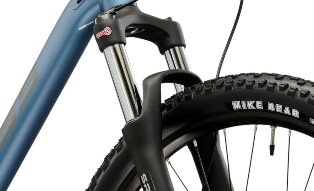 Rower górski MTB KROSS XPRT 9.2 M18 29 cali męski Niebiesko-grafitowy zbliżenie na amortyzator widok lekko pod skosem rower typu hardtail przedni amortyzator SR Suntour typu XCM RL ze skokiem 100 mm ułatwia najeżdżanie na przeszkody niweluje wstrząsy niska masa roweru duża sztywność regulacja za pomocą sprężyny obsługa poprzez manetkę