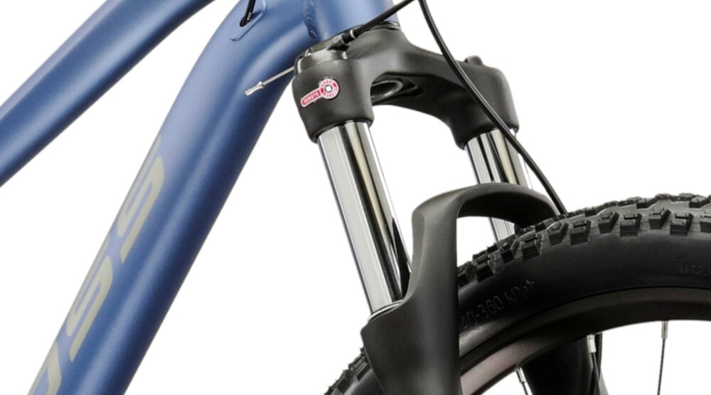 Zbliżenie na przednią część roweru górskiego z widocznym amortyzatorem i fragmentem opony. Rama roweru jest w kolorze niebiesko-szarym z widocznym logo producenta.