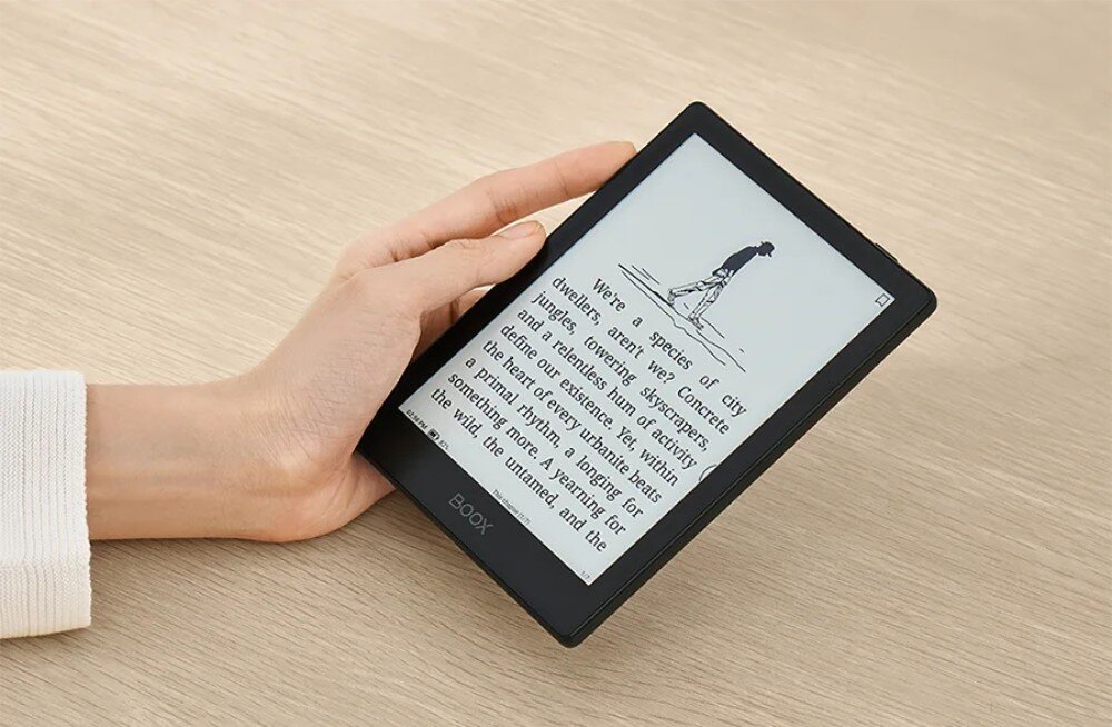 Czytnik e-booków ONYX BOOX Go Dłoń trzymająca czytnik z wyświetlonym tekstem i ilustracją przedstawiającą postać idącą z torbą i tekstem poniżej, ekran, rozdzielczość, podświetlenie, regulacja