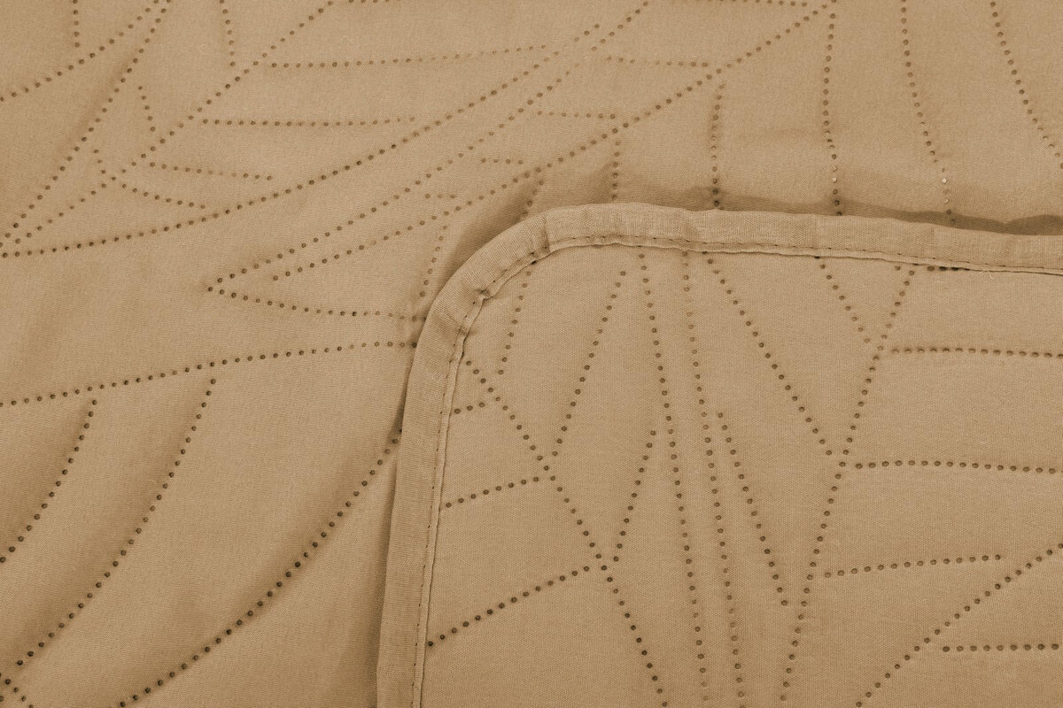 Beżowa narzuta z tłoczonym wzorem w kształcie liści, wykonana z mikrofibry. Widoczny jest fragment narzuty z zaokrąglonym rogiem.