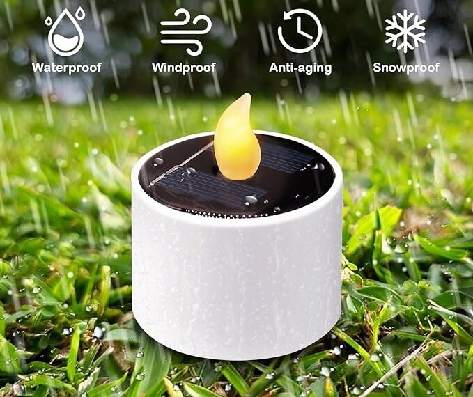 Na obrazie widoczna jest biała świeca LED z efektem płomienia, umieszczona na trawie podczas deszczu. Nad nią znajdują się ikony z napisami: \'Waterproof\', \'Windproof\', \'Anti-aging\', \'Snowproof\'.