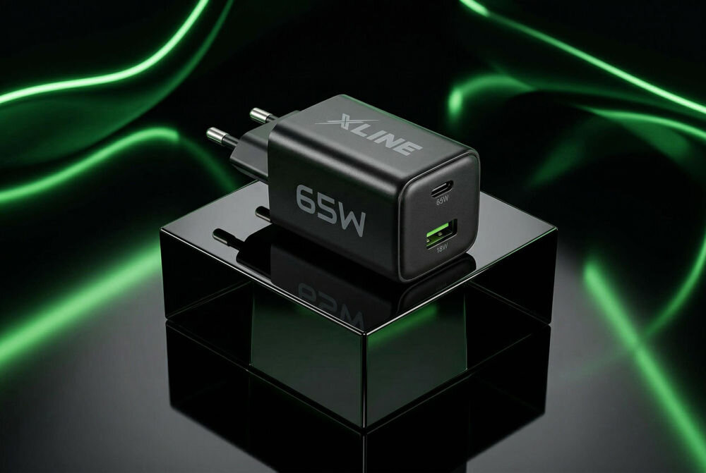 Czarna ładowarka sieciowa z logo \'XLINE\' i oznaczeniem \'65W\' na obudowie, posiada dwa porty: USB-C z oznaczeniem \'65W\' i USB-A z oznaczeniem \'18W\'. Ładowarka jest umieszczona na błyszczącej powierzchni z zielonymi świetlnymi efektami w tle.