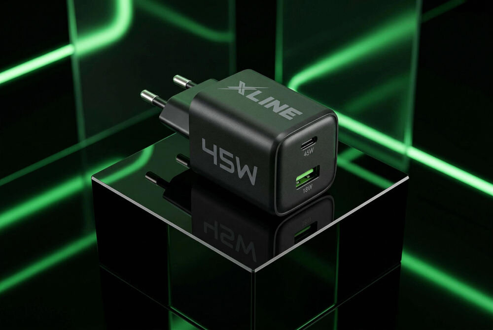 Czarna ładowarka sieciowa z logo \'XLINE\' i oznaczeniem \'45W\' na obudowie, posiada dwa porty: USB-C z oznaczeniem \'45W\' i USB-A z oznaczeniem \'18W\'. Ładowarka jest umieszczona na błyszczącej, czarnej powierzchni z zielonymi, świetlnymi liniami w tle.