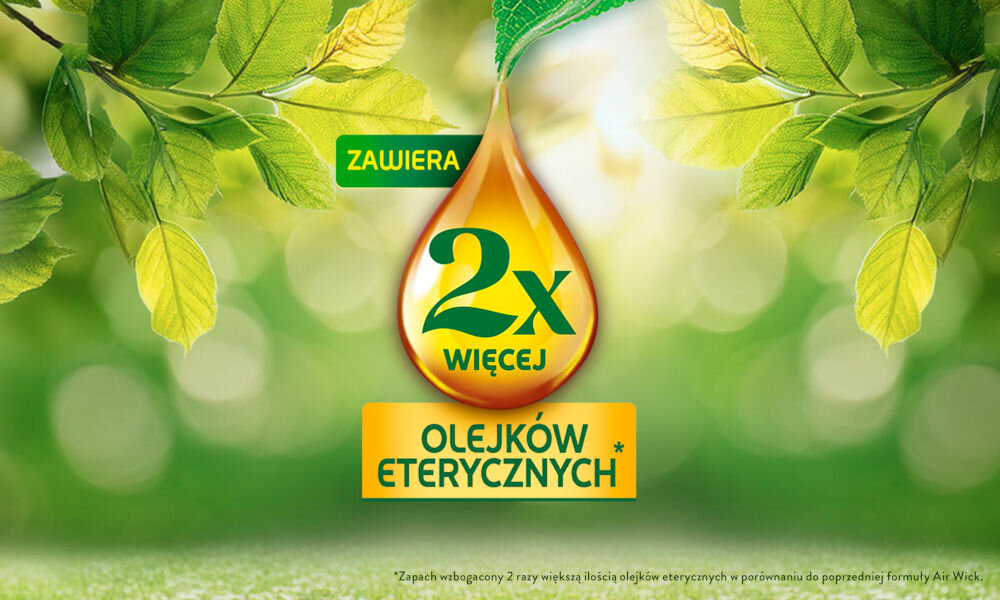 Obraz przedstawia kroplę z napisem \'ZAWIERA 2x WIĘCEJ OLEJKÓW ETERYCZNYCH\' na tle zielonych liści. W dolnej części znajduje się mały tekst: \'Zapach wzbogacony 2 razy większą ilością olejków eterycznych w porównaniu do poprzedniej formuły Air Wick\'.
