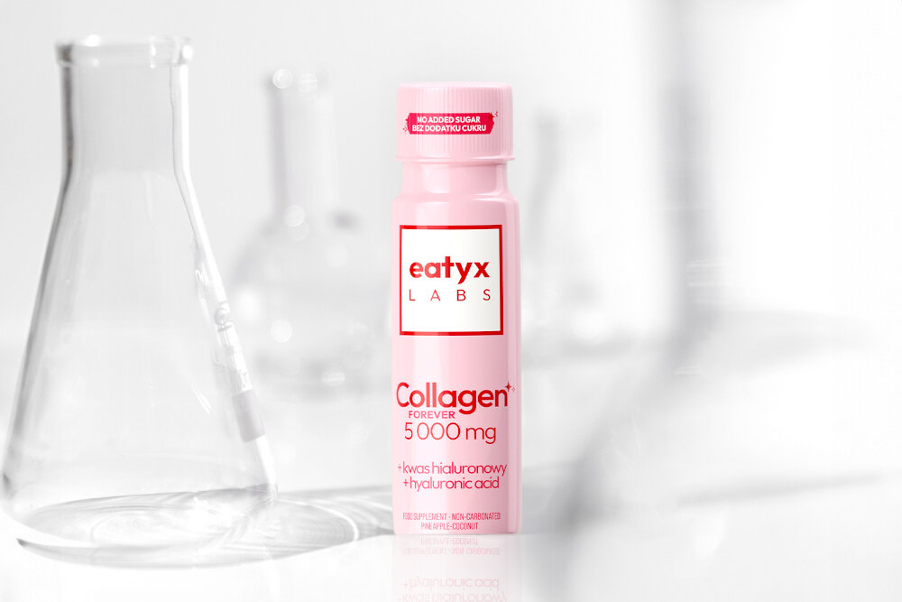 Kolagen EATYX Labs forever 5000 mg Ananasowo-kokosowy 80 ml jasne tło szklana próbówka obok stoi buteleczka kolagenu nie zawiera dodatku cukru, glutenu ani sztucznych barwników bez składników pochodzących z ryb i owoców morza wspiera wygląd skóry kondycję włosów i paznokci wygodna forma spójna kompozycja do codziennej suplementacji