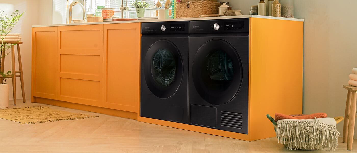 Stylowa pomarańczowa zabudowa z kompletem urządzeń złożonym z pralki i suszarki Samsung BESPOKE AI™ Stylowa pomarańczowa zabudowa z kompletem urządzeń złożonym z pralki i suszarki Samsung BESPOKE AI™
