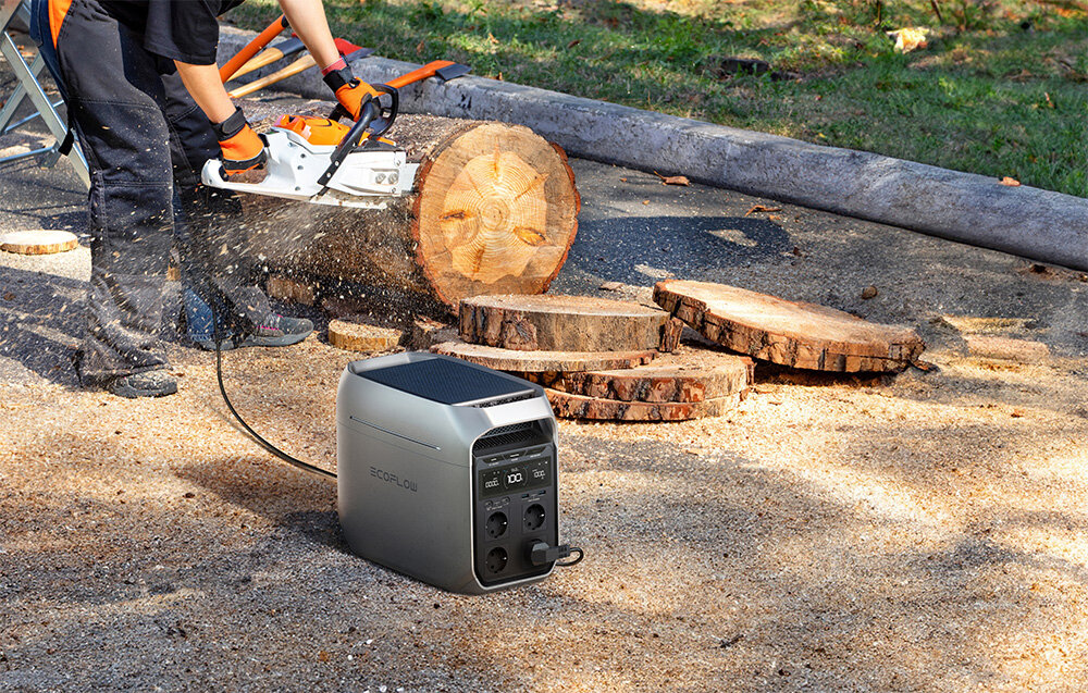 Przenośna stacja zasilania EcoFlow DELTA 3 Plus, Wsparcie na medal, Stacja na pierwszym planie, w tle podłączona do pilarki, którą obsługuje osoba