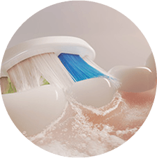 Zbliżenie na szczoteczkę czyszczącą zęby i wytwarzającą mikrobąbelki.