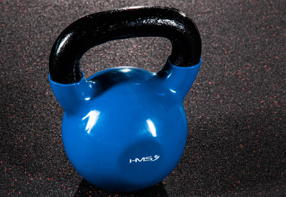 Kettlebell HMS KNV20 (20 kg) Niebiesko-czarny podłoga kettlebell stoi na podłodze widok z góry lekko pod skosem płaskie i stabilne dno bezpieczne odstawianie sprzętu po każdej serii bez ryzyka przewrócenia lub toczenia się po podłodze zwiększa komfort użytkowania ułatwia przerwy między ćwiczeniami szybkie zmiany stanowiska treningowego