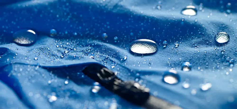 Materiał outdoorowy na którym widać krople wody, które się nie wchłaniają