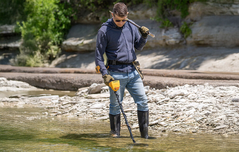 Wykrywacz metalu GARRETT ACE 250, Garrett ACE 250, wykrywacz, metale, poszukiwania, Mężczyzna w woderach szuka skarbów w wodzie z Garrett ACE 250.