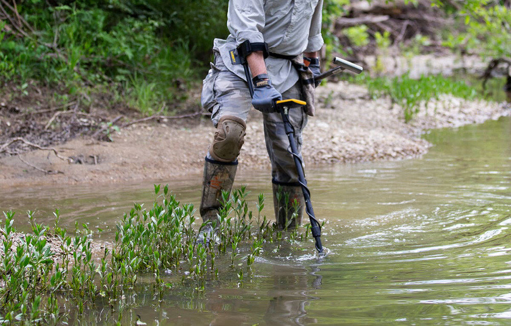 Wykrywacz metalu GARRETT ACE Apex, Iron Audio, głośność, kapsle, dyskryminacja, Poszukiwacz używa wykrywacza metali w płytkiej rzece.