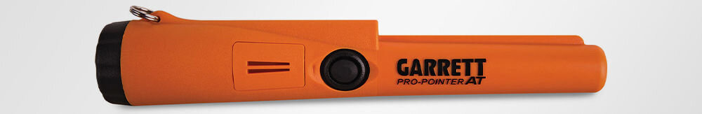 Pomarańczowy wykrywacz metalu z czarnym przyciskiem i napisem \'GARRETT PRO-POINTER AT\'.