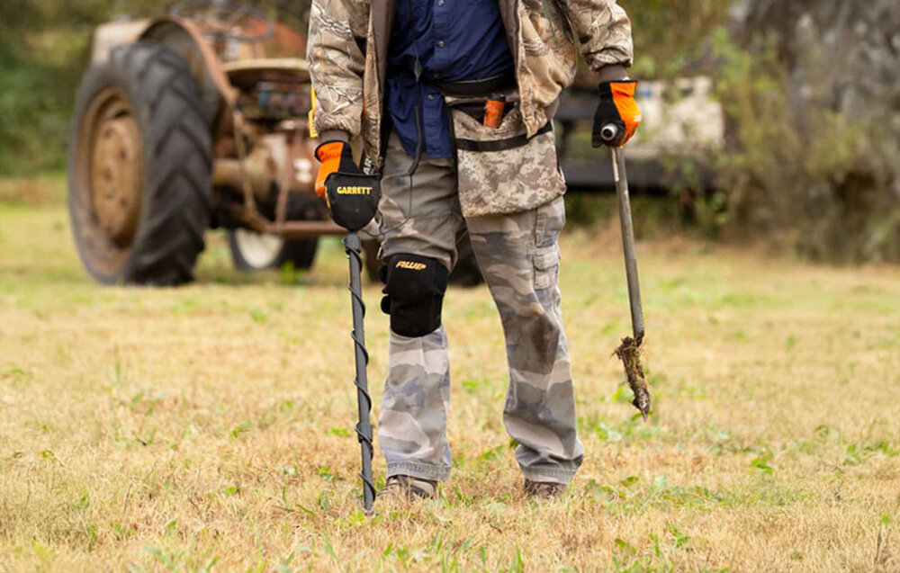 Wykrywacz metalu GARRETT ACE 300i, częstotliwość, zakłócenia, sygnały, detektoryści, Poszukiwacz w stroju moro używa wykrywacza Garrett ACE na polu.