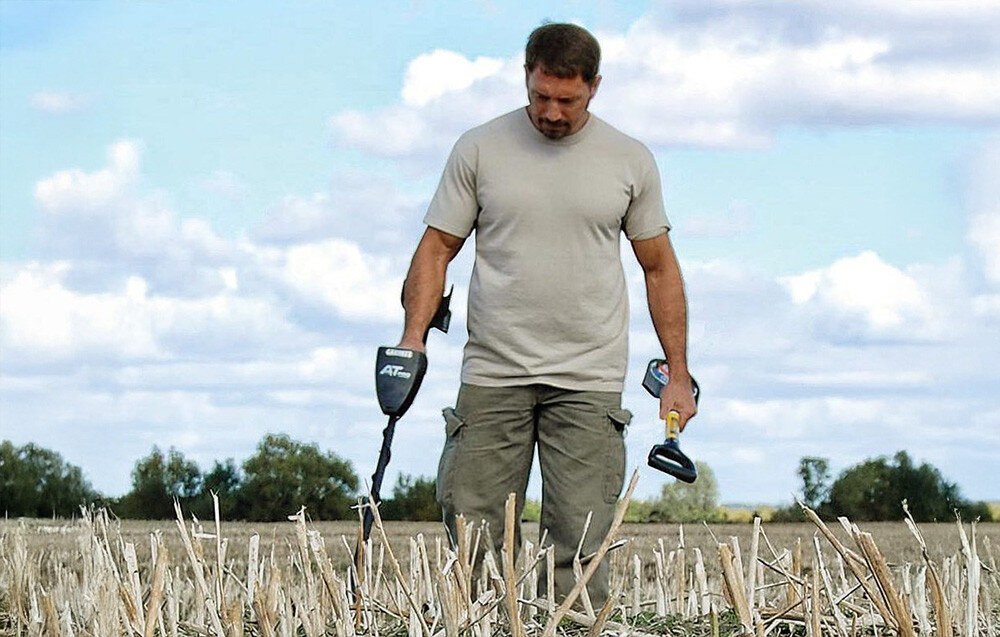 Wykrywacz metalu GARRETT AT Pro-International, detekcja, metale, sygnały, analiza, Mężczyzna używający wykrywacza metali na polu.