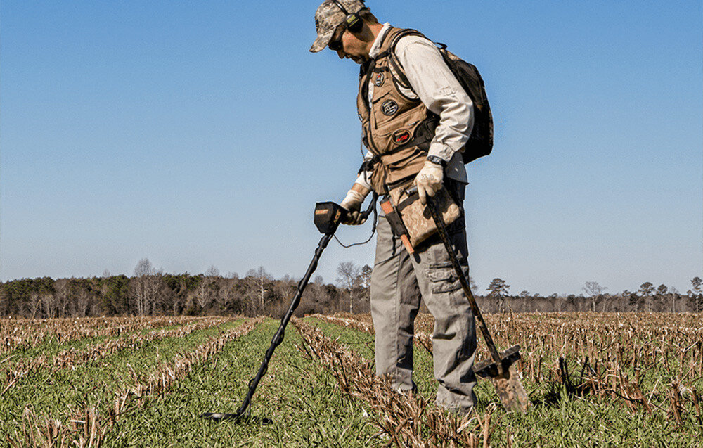 Wykrywacz metalu GARRETT ACE 400i, poszukiwania, kontrola, metale, odkrywcy, Mężczyzna z wykrywaczem metali na rozległym, skoszonym polu.
