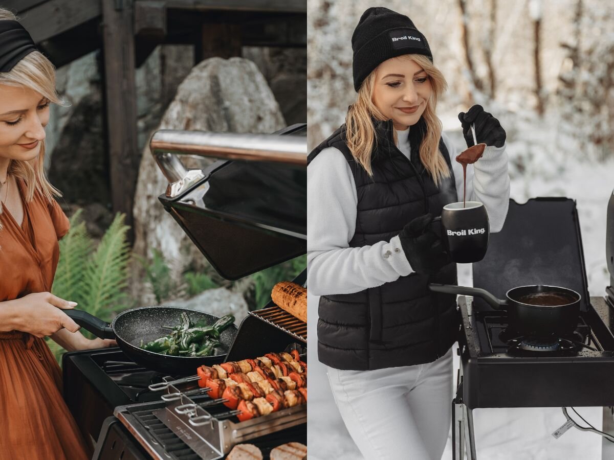 Na zdjęciu widać osobę gotującą na grillu gazowym, na którym znajdują się szaszłyki i patelnia z warzywami. Obok inna osoba trzyma kubek z napisem \'Broil King\' i gotuje na bocznym palniku grilla.
