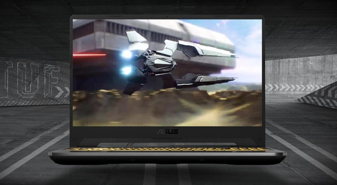 Laptop ASUS TUF Gaming A15 otwarty na tle industrialnej hali, na ekranie dynamiczna scena z gry science-fiction – futurystyczny statek kosmiczny w locie, podświetlana na żółto klawiatura, masywna obudowa, logo ASUS pod ekranem. - 144 Hz 1920 x 1080 px Adaptive-Sync 