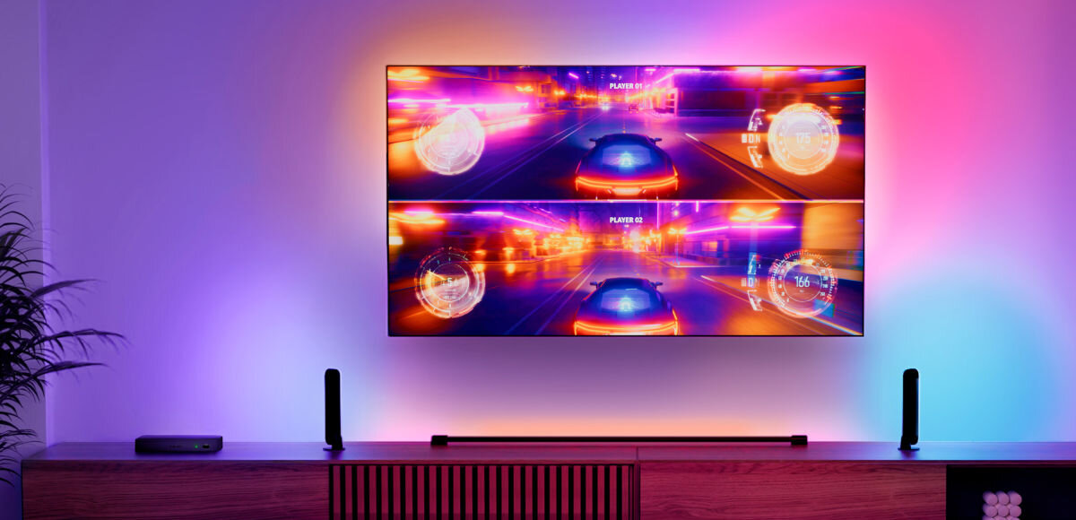 Centralka PHILIPS HUE 929003499601, dopasowanie, jakość, HZ, 8k, częstotliwość, telewizor w różnych barwach na ekranie, w tle pomieszczenie pokoju gościnnego