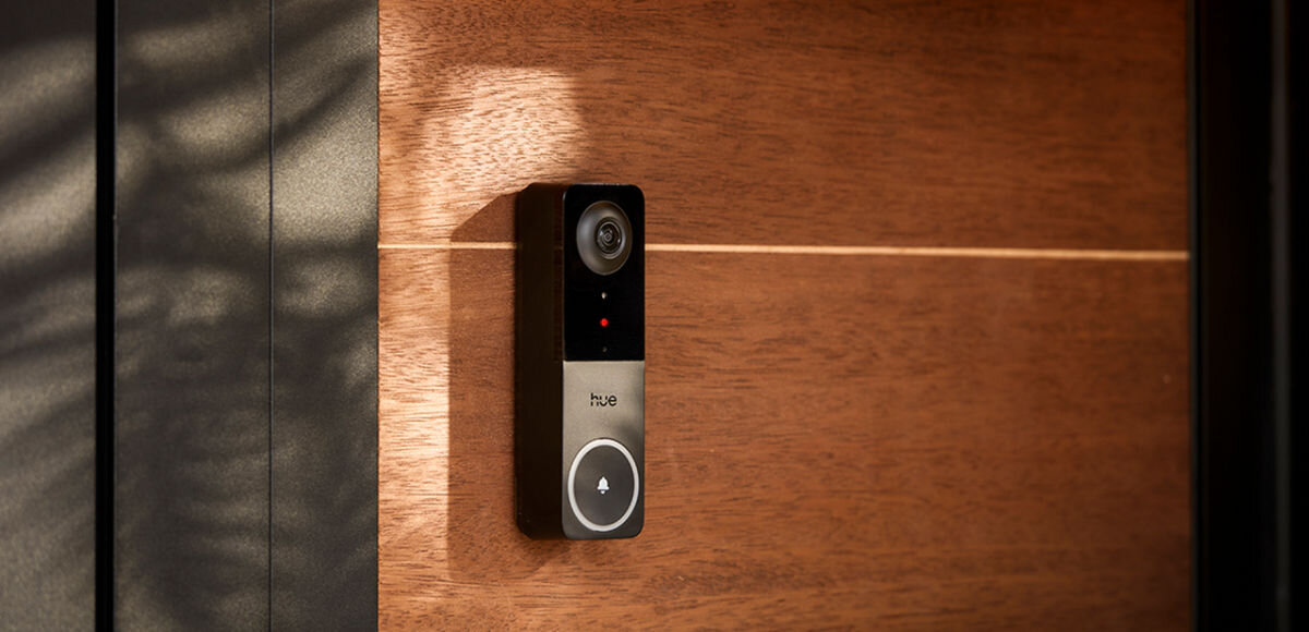Wideodzwonek PHILIPS HUE 929003816503 Bezprzewodowy Wi-Fi Biało-czarny, spójny, światło, automatyczne, zwiększając, Czarny wideodomofon Hue Secure zamontowany na drewnianych drzwiach wejściowych w promieniach światła.