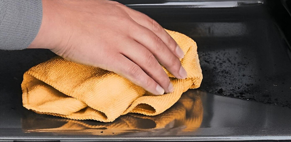 KUCHNIA MIKROFALOWA BOSCH BEL554MB0 dłoń szamtka czyszczenie wycieranie wnętrza kuchenka mikrofalowa szybkie czyszczenie woda detergent funkcja czyszczenia ekologiczna metoda zmiękczanie resztek łatwe czyszczenie szybki proces efektywne czyszczenie wnętrze ściereczka