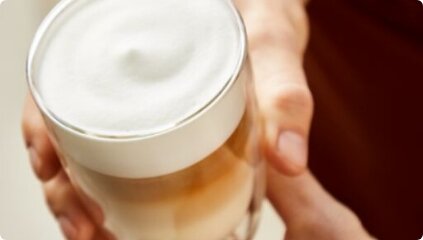 Zbliżenie na kawę trzymaną w ręce.