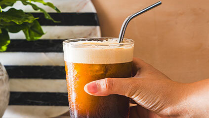 Zbliżenie na kawę trzymaną w ręce.